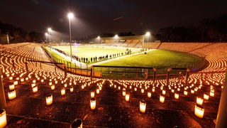  Der Künstler Volker-Johannes Trieb hat 20000 Kerzen in einem Fußballstadtion positionieren lassen.