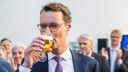 Hendrik Wüst trinkt ein Bier