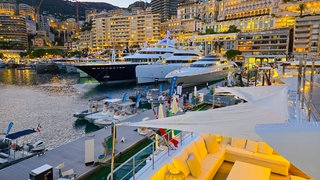 Yacht in Monte Carlo, Monaco im Hafen vor leichtenden Häusern 