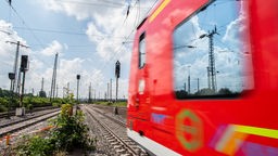  In der Scheibe einer Regionalbahn, die Richtung Dortmund fährt, spiegeln sich Hochspannungsleitungen