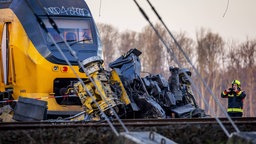 Person macht ein Foto vom mit einem Baukran kollidierten Zug in den Niederlanden.