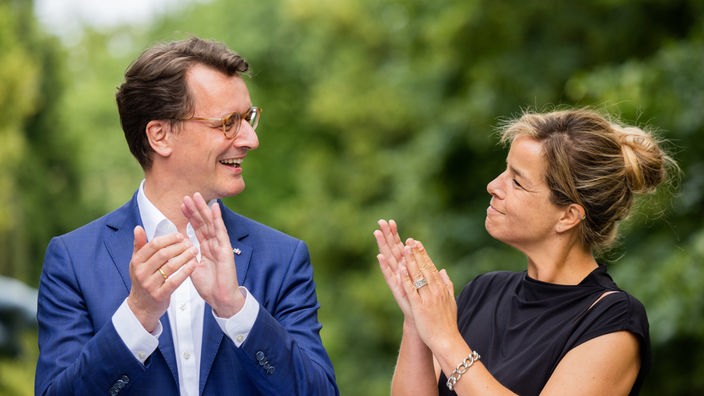 Hendrik Wüst  und Mona Neubaur stehen im Garten 