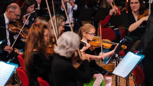 Mädchen spielt Violine mit Musikerinnen des WDR Sinfonieorchester