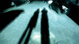 Verschwommenes Schattenbild von 2 Männern auf der Straße bei Nacht.