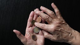 Hände eines alten Menschen halten Geld