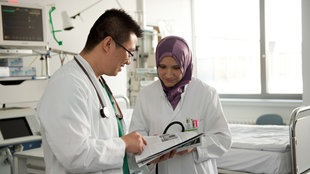 Die Assistenzärzte Sandy Wijaya (l) und Boshra Khadoura unterhalten sich am 16.07.2013 in Dortmund (Nordrhein-Westfalen) im Klinikum Dortmund