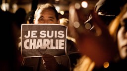 Ein Mann hält bei einer Demo ein Schild mit der Aufschrift "Je Suis Charlie" hoch