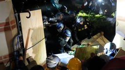 Die Polizei durchbricht eine Absperrung, die von pro-palästinensischen Demonstranten auf dem UCLA-Campus errichtet wurde. 