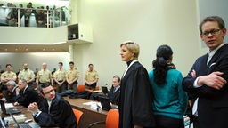 Die Angeklagte Beate Zschäpe (2.v.r.) steht am 22.01.2014 im Gerichtssaal des Oberlandesgerichts in München (Bayern) bei ihren Anwälten, Wolfgang Stahl (l), Anja Sturm und Wolfgang Heer
