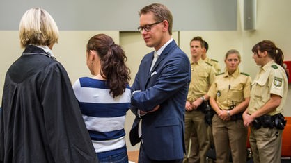 Die Angeklagte Beate Zschäpe (M) ist am 05.11.2014 im Gerichtssaal des Oberlandesgerichts in München (Bayern) neben ihren Anwälten Anja Sturm und Wolfgang Heer (r) zu sehen