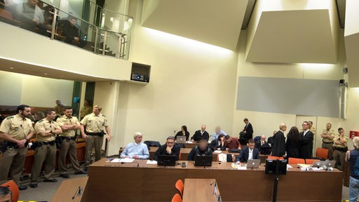 Die Angeklagte Beate Zschäpe steht am 14.10.2014 im Gerichtssaal in München (Bayern) zwischen ihren Anwälten Anja Sturm (l) und Wolfgang Heer (r) hinter der Anklagebank