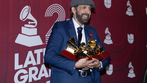 Juan Luis Guerra hält seine Grammy-Auszeichnungen für die Platte des Jahres, das beste Merengue/Bachata-Album und den besten tropischen Song während der 25. Latin-Grammy-Verleihung 2024 