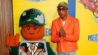 Pharrell Williams neben einer großen LEGO-Figur bei der New Yorker Premiere von "Piece by Piece", in New York City (2024)