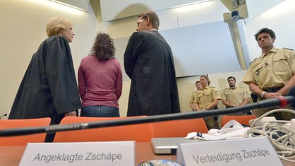 Die Angeklagte Beate Zschäpe (2.v.l.) steht am 06.08.2014 im Gerichtssaal in München (Bayern) zwischen ihren Anwälten Anja Sturm (l) und Wolfgang Heer (3.v.l.)