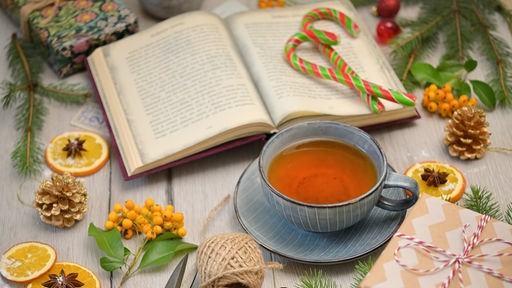 Teetasse mit Buch und Weihnachtsdeko