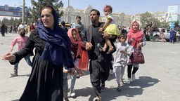 Eine Familie versucht auf dem Flughafen der afghanischen Hauptstadt Kabul aus dem Land zu fliehen