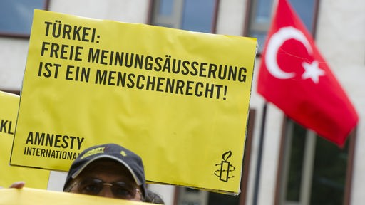 Ein Unterstützer der Menschenrechtsorganisation Amnesty International nimmt an einer Protestaktion teil