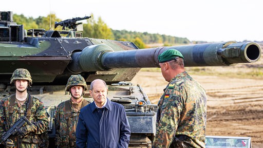 Bundeskanzler Olaf Scholz (SPD, 2.v.r) lässt sich vor der Ausbildungs- und Lehrübung des Heeres im Landkreis Heidekreis den Kampfpanzer Leopard2 der Bundeswehr erklären