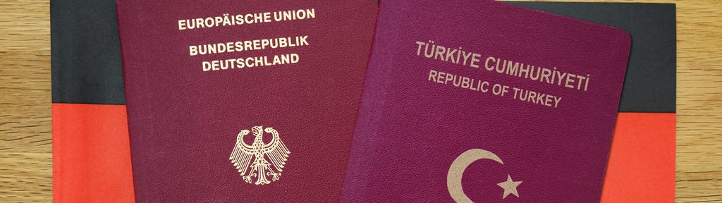 Deutscher und türkischer Reisepass vor einer vor Deutschlandfahne