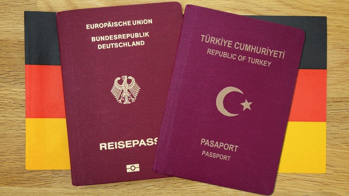 Deutscher und türkischer Reisepass vor einer vor Deutschlandfahne