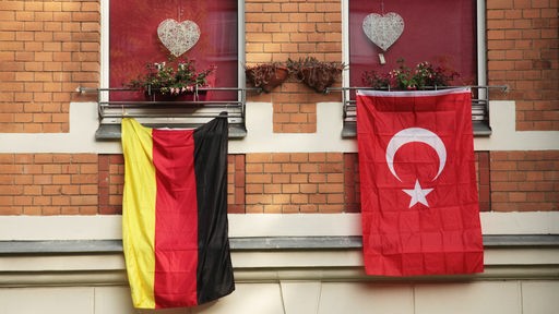 Flaggen von Deutschland und der Türkei hängen an einer Hausfassade
