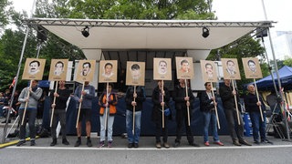 München: Demonstranten halten bei einer Kundgebung vor dem Oberlandesgericht Schilder mit Abbildung der NSU-Opfer