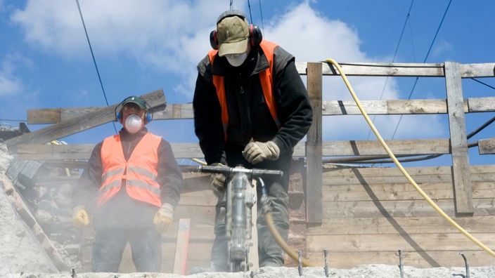 Zwei Bauarbeiter auf der Baustelle mit Presslufthammer