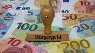 Symbobild Bürgergeld, Geld und Stempel "Bürgegeld"