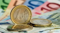 Ein Euro Münze und Geldscheine