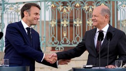 Il Presidente francesce Emmanuel Macron stringe la mano al cancelliere tedesco Olaf Scholz