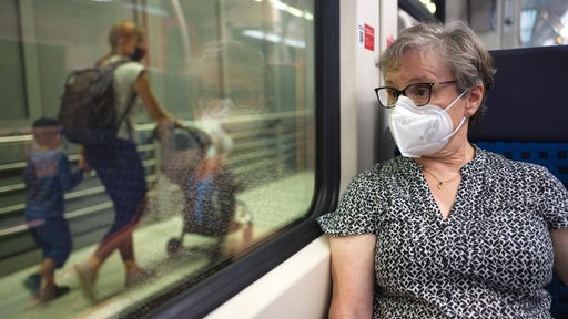 Eine Frau trägt in der U-Bahn eine Covid-Maske