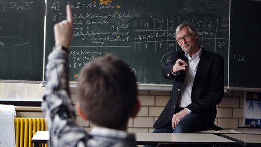 Symbolbild Unterricht in der Schule mit Lehrer und Schüler