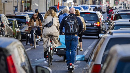 Una strada trafficata con biciclette, pedoni e auto