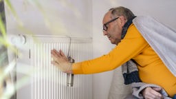 Un signore accosta la mano ad un termosifone