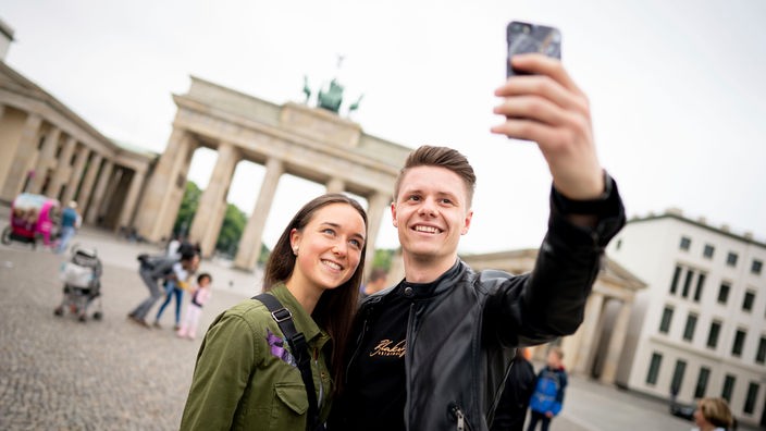 Turisti che fanno un selfie davanti alla porta di Brandeburgo  