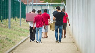 Reforma azila; ilustracija - grupa migranata ulazi u logor za privremeni smeštaj