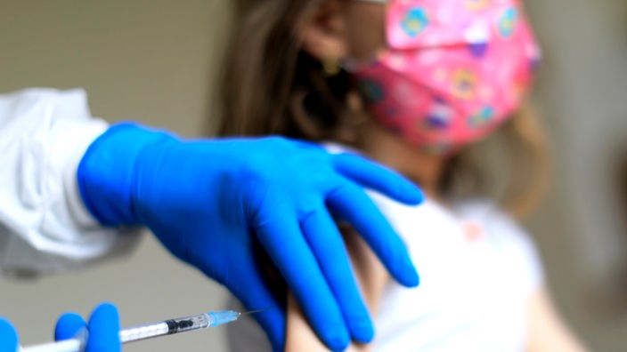 Vakcinisanje devojčice sa zaštitnom maskom
