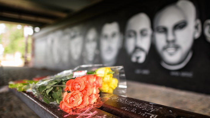 Grafit posvećen žrtavama napada u Hanau i buket cveća ispred njega