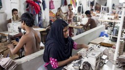 Jedna žena i nekoliko dece rade u fabrici odeće u Bangladešu