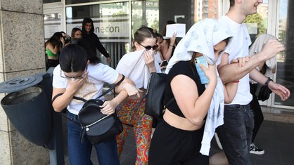 Aktivisti Srpske napredne stranke kriju lica dok beže iz kol centra u Novom Sadu