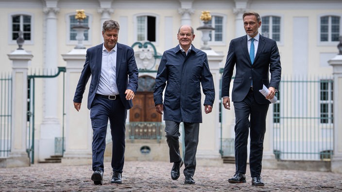 Vor dem Schloss Meseberg laufen am 29.08.2023 (von links) Wirtschaftsminister Robert Habeck (Grüne), Bundeskanzler Olaf Scholz (SPD) und Finanzminister Christian Lindner (FDP).