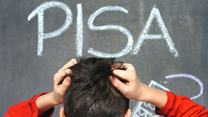 Dečak se čupa za kosu ispred table na kojoj piše PISA