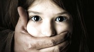 Ruka odrasle osobe drži zatvorena usta devojčice