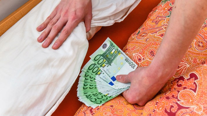 Ruke guraju novac ispod dušeka