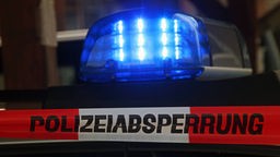 Traka sa natpisom "Polizeiabsperrung (Zabranjen pristup, policija)" i rotaciono svetlo u pozadini