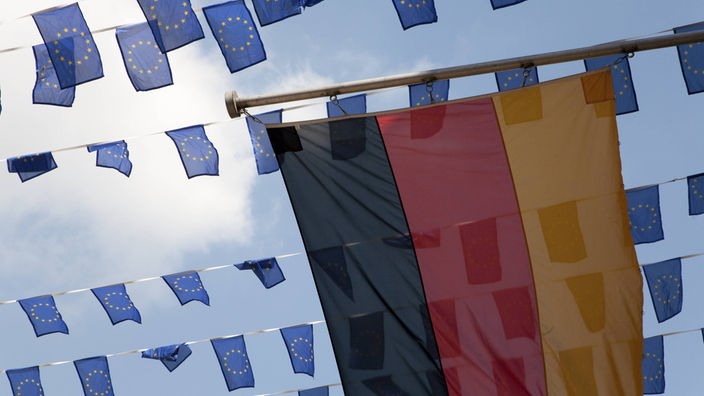 Velika zastava Nemačke, a iza nje mnogo malih zastava EU