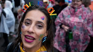 Učesnica Europride-a sa rajfom u kosi na kome su slova "LOVE IS LOVE" u duginim bojama