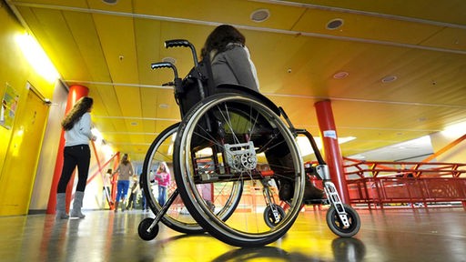 Eine behinderte Schülerin sitzt im Rollstuhl
