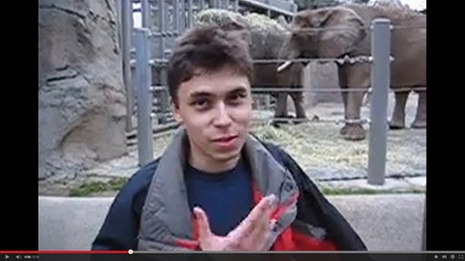 Jawed Karim, Mitgründer von YouTube, vor einem Elefantengehege im ersten Video, das je auf YouTube hochgeladen wurde "Me at the zoo"