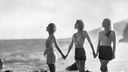 Die drei Schauspielerinnen Adrienne Ames, Frances Dee und Judith Wood posen 1931 Hand in hand an einem Strand in Kalifornien.